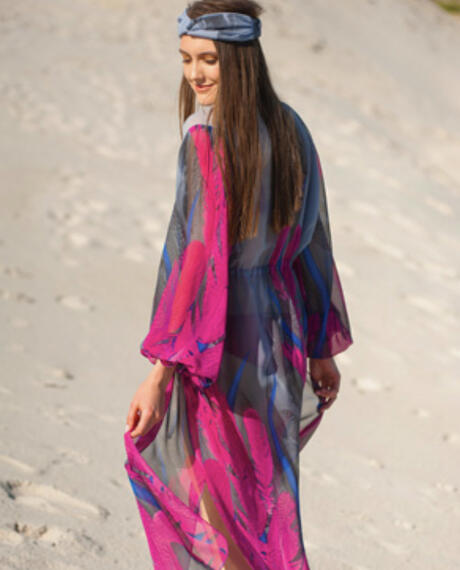 Flowing, sheer kaftan-style dress with a vivid pattern over swimwear.